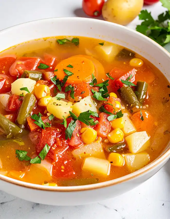 Vegetable Soup with carrots, potatoes, green beans, corn kernels, and tomatoes