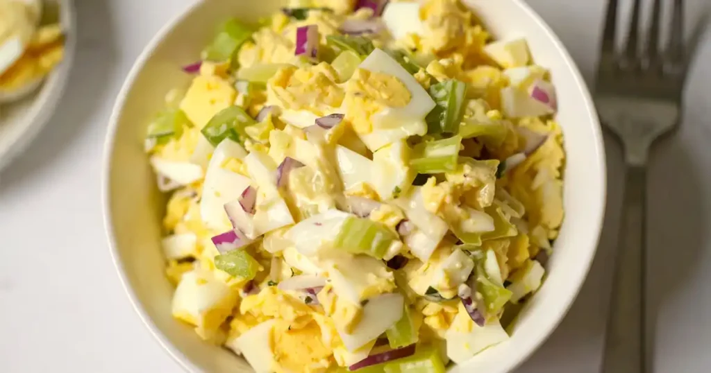 A bowl of egg salad with celery and mayo