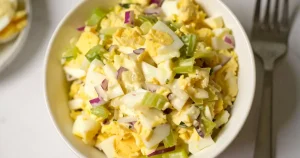 A bowl of egg salad with celery and mayo