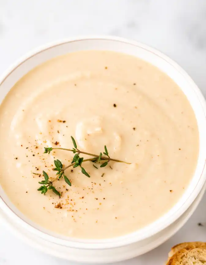 smooth and creamy  Roasted Cauliflower Soup, garnished with fresh thyme